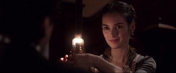 Movie still from “The Age of Innocence” (1993), directed by Martin Scorsese – A woman is holding a candle in her hand; Close Up shot, Over the shoulder angle
