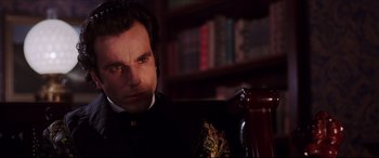 Movie still from “The Age of Innocence” (1993), directed by Martin Scorsese – A man sitting in a chair in a library; Close Up shot, Over the shoulder angle