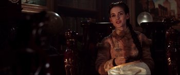 Movie still from “The Age of Innocence” (1993), directed by Martin Scorsese – A young woman in a victorian era dress holding a lamp; Medium shot, Over the shoulder angle