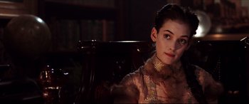 Movie still from “The Age of Innocence” (1993), directed by Martin Scorsese – A woman sitting in a chair wearing a fur collar; Close Up shot, Over the shoulder angle