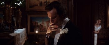 Movie still from “The Age of Innocence” (1993), directed by Martin Scorsese – A man smoking a cigarette in front of a painting; Close Up shot, Over the shoulder angle