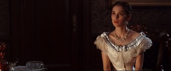 Movie still from “The Age of Innocence” (1993), directed by Martin Scorsese – A woman in a white dress and a silver necklace; Close Up shot, Over the shoulder angle