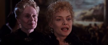 Movie still from “The Age of Innocence” (1993), directed by Martin Scorsese – A woman with blonde curly hair and red lipstick; Close Up shot, Over the shoulder angle