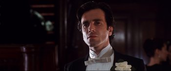 Movie still from “The Age of Innocence” (1993), directed by Martin Scorsese – A person wearing a suit and bow tie; Close Up shot, Low angle
