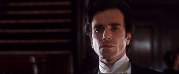 Movie still from “The Age of Innocence” (1993), directed by Martin Scorsese – A person wearing a suit and tie; Close Up shot, Low angle