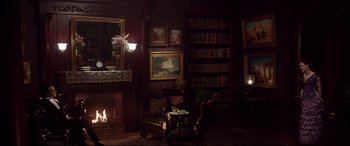 Movie still from “The Age of Innocence” (1993), directed by Martin Scorsese – A living room filled with furniture next to a fire place; Wide shot, High angle