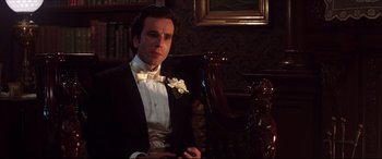 Movie still from “The Age of Innocence” (1993), directed by Martin Scorsese – A man in a tuxedo sitting in a chair; Close Up shot, Low angle