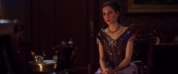 Movie still from “The Age of Innocence” (1993), directed by Martin Scorsese – A woman in a purple dress sitting on a chair; Medium shot, Over the shoulder angle