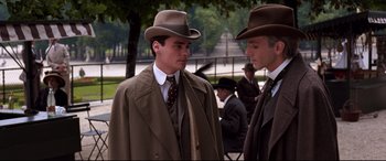 Movie still from “The Age of Innocence” (1993), directed by Martin Scorsese – Two men in suits and hats are standing outside; Medium shot, Low angle