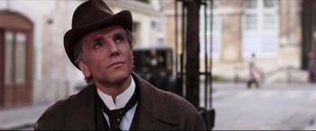 Movie still from “The Age of Innocence” (1993), directed by Martin Scorsese – A man wearing a brown hat and a brown coat; Close Up shot, Low angle