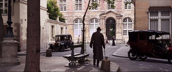 Movie still from “The Age of Innocence” (1993), directed by Martin Scorsese – A man in a long coat and hat is walking down the street; Wide shot, High angle