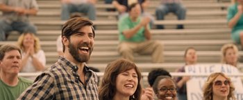 Movie still from “The Big Short” (2015), directed by Adam McKay – A man and a woman laughing in front of a crowd; Medium shot, Over the shoulder angle