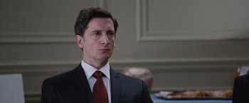 Movie still from “The Big Short” (2015), directed by Adam McKay – A person wearing a suit and tie; Close Up shot, Over the shoulder angle