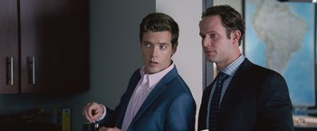 Movie still from “The Big Short” (2015), directed by Adam McKay – A man in a suit and tie standing next to another man in a suit and tie; Close Up shot, Over the shoulder angle