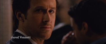 Movie still from “The Big Short” (2015), directed by Adam McKay – A person wearing a suit and tie; Close Up shot, Over the shoulder angle