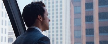 Movie still from “The Big Short” (2015), directed by Adam McKay – A person wearing a suit looking out a window; Close Up shot, Over the shoulder angle
