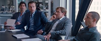 Movie still from “The Big Short” (2015), directed by Adam McKay – Two men in suits sitting at a conference table; Medium shot, Over the shoulder angle