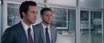 Movie still from “The Big Short” (2015), directed by Adam McKay – Two men in suits and ties standing next to each other in a room; Close Up shot, Over the shoulder angle
