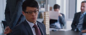 Movie still from “The Big Short” (2015), directed by Adam McKay – A man in a suit and tie sitting at a table; Close Up shot, Over the shoulder angle
