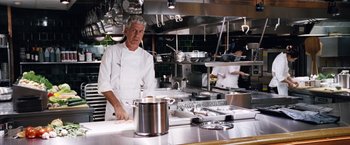 Movie still from “The Big Short” (2015), directed by Adam McKay – A man standing in front of a stove in a kitchen; Medium shot, Over the shoulder angle
