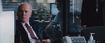 Movie still from “The Big Short” (2015), directed by Adam McKay – A man in a suit and tie sitting in front of a window; Close Up shot, Over the shoulder angle