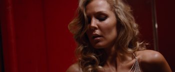 Movie still from “The Big Short” (2015), directed by Adam McKay – A woman with long blonde curly hair looking to her left; Close Up shot, Low angle