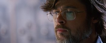 Movie still from “The Big Short” (2015), directed by Adam McKay – A person wearing glasses and a beard; Close Up shot, Low angle