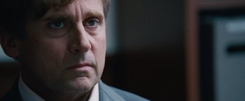 Movie still from “The Big Short” (2015), directed by Adam McKay – A person wearing a suit and tie; Close Up shot, Over the shoulder angle