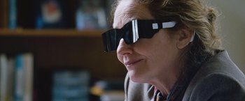 Movie still from “The Big Short” (2015), directed by Adam McKay – A woman wearing a pair of sunglasses with a reflection of a camera; Close Up shot, Over the shoulder angle