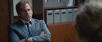 Movie still from “The Big Short” (2015), directed by Adam McKay – A man sitting in a chair with his arms crossed; Close Up shot, Over the shoulder angle