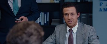 Movie still from “The Big Short” (2015), directed by Adam McKay – A person wearing a suit and tie; Close Up shot, Over the shoulder angle