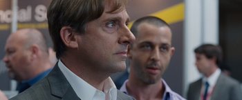 Movie still from “The Big Short” (2015), directed by Adam McKay – A man in a suit and tie next to another man in a suit and tie; Close Up shot, Over the shoulder angle