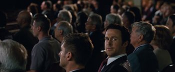 Movie still from “The Big Short” (2015), directed by Adam McKay – A group of people sitting in front of each other; Close Up shot, Over the shoulder angle