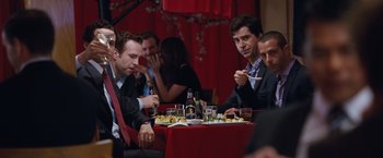 Movie still from “The Big Short” (2015), directed by Adam McKay – A group of people sitting at a table eating; Medium shot, Over the shoulder angle