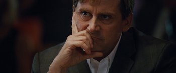 Movie still from “The Big Short” (2015), directed by Adam McKay – A person with his hand on his chin; Close Up shot, Low angle