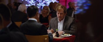 Movie still from “The Big Short” (2015), directed by Adam McKay – Two men are sitting at a table with food and drinks; Medium shot, Over the shoulder angle