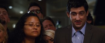 Movie still from “The Big Short” (2015), directed by Adam McKay – A man and woman standing next to each other in front of a crowd; Close Up shot, Over the shoulder angle