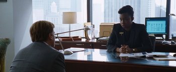 Movie still from “The Big Short” (2015), directed by Adam McKay – Two people sitting at a desk in front of each other; Medium shot, Over the shoulder angle