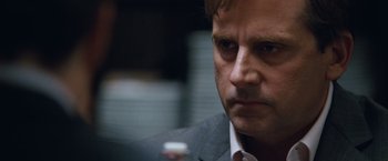 Movie still from “The Big Short” (2015), directed by Adam McKay – A person wearing a suit and tie; Close Up shot, Over the shoulder angle