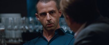 Movie still from “The Big Short” (2015), directed by Adam McKay – A person wearing a blue shirt; Close Up shot, Over the shoulder angle