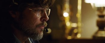 Movie still from “The Big Short” (2015), directed by Adam McKay – A person wearing glasses and smoking a pipe; Close Up shot, Low angle