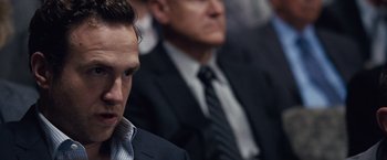 Movie still from “The Big Short” (2015), directed by Adam McKay – A man in a suit and tie sitting next to another man in a suit and tie; Close Up shot, Over the shoulder angle