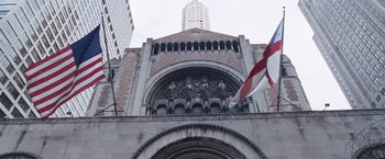Movie still from “The Big Short” (2015), directed by Adam McKay – A large building with a flag on the front of it; Extreme Wide shot, Low angle