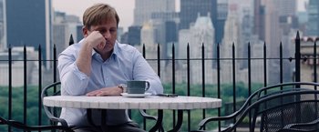 Movie still from “The Big Short” (2015), directed by Adam McKay – A man sitting at a table with a cup of coffee; Medium shot, Over the shoulder angle