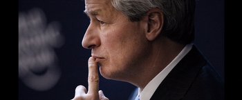 Movie still from “The Big Short” (2015), directed by Adam McKay – A person wearing a suit and holding his finger to his mouth; Close Up shot, Low angle