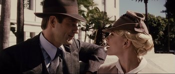 Movie still from “The Black Dahlia” (2006), directed by Brian De Palma – A man and a woman wearing suits and hats; Close Up shot, Low angle