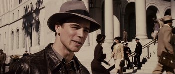 Movie still from “The Black Dahlia” (2006), directed by Brian De Palma – A man wearing a hat standing in front of a group of people; Close Up shot, Low angle
