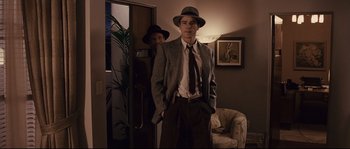 Movie still from “The Black Dahlia” (2006), directed by Brian De Palma – A man in a suit and hat standing next to another man in a suit and hat; Medium shot, Over the shoulder angle