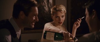 Movie still from “The Black Dahlia” (2006), directed by Brian De Palma – A woman holding a bottle of wine in front of a man; Close Up shot, Over the shoulder angle