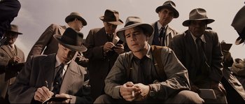 Movie still from “The Black Dahlia” (2006), directed by Brian De Palma – A group of men in suits and hats smoking cigarettes; Medium shot, Low angle
